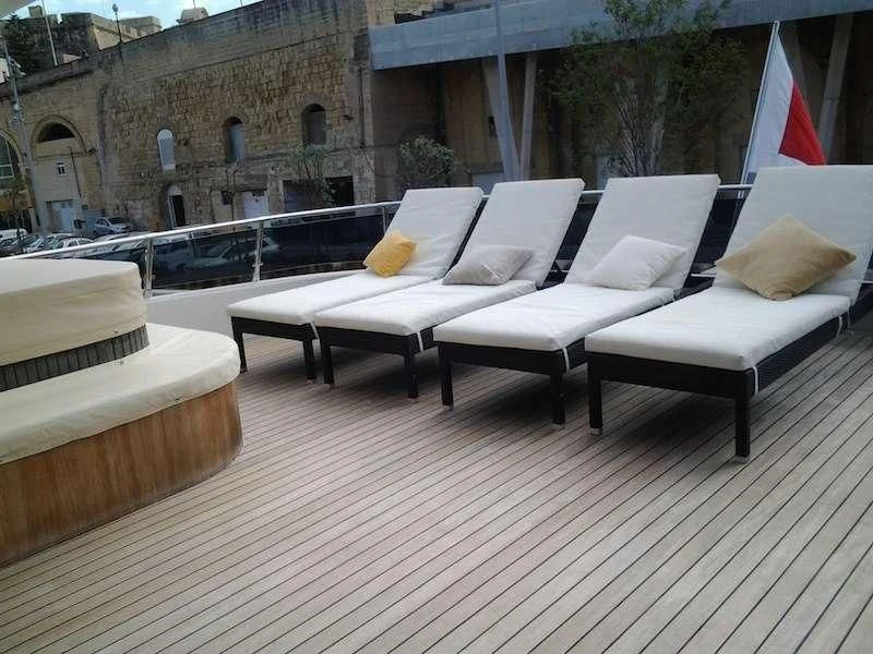 a deck with couches and chairs aboard ARIA Yacht for Sale