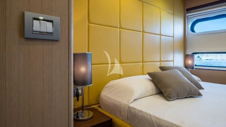 a room with a bed and a lamp aboard ARIA Yacht for Sale