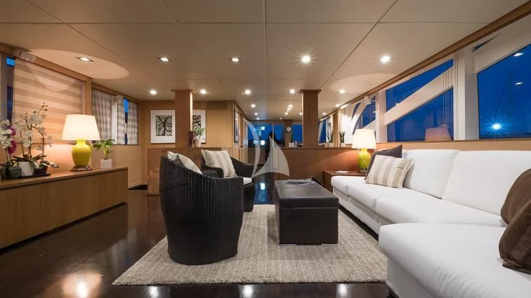 a large living room with white couches and a large window aboard ARIA Yacht for Sale