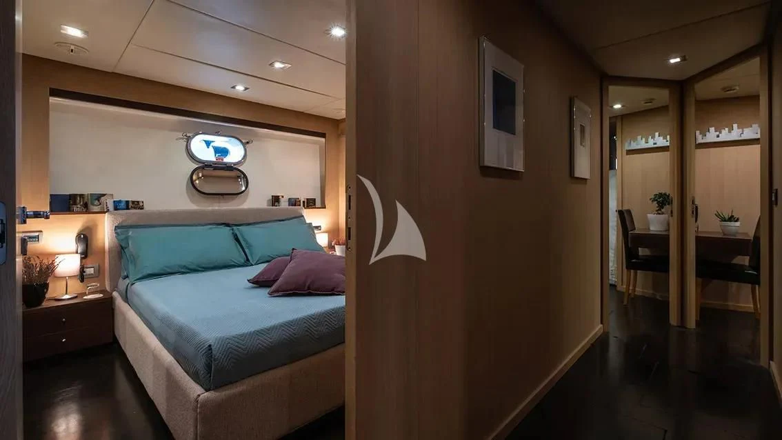 a bedroom with a bed and a desk aboard ARIA Yacht for Sale