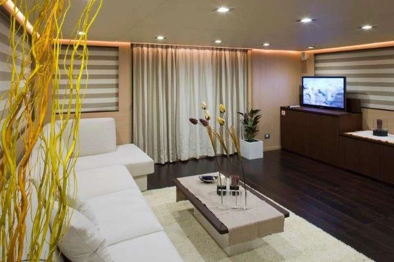 a living room with a tv and sofa aboard ARIA Yacht for Sale