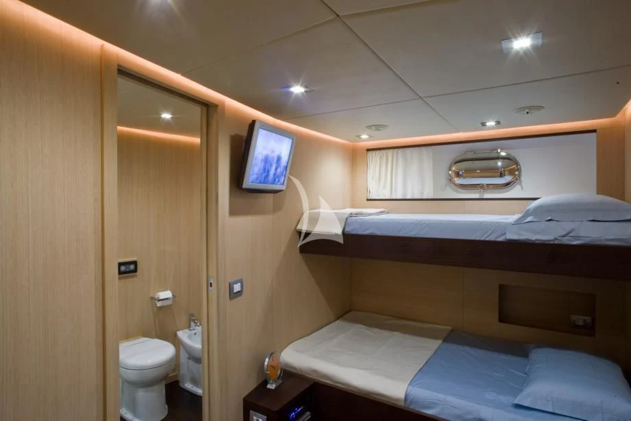 a room with a bed and a television aboard ARIA Yacht for Sale