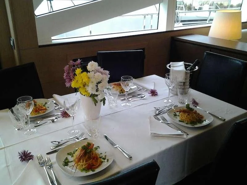 a table with plates and glasses aboard ARIA Yacht for Sale