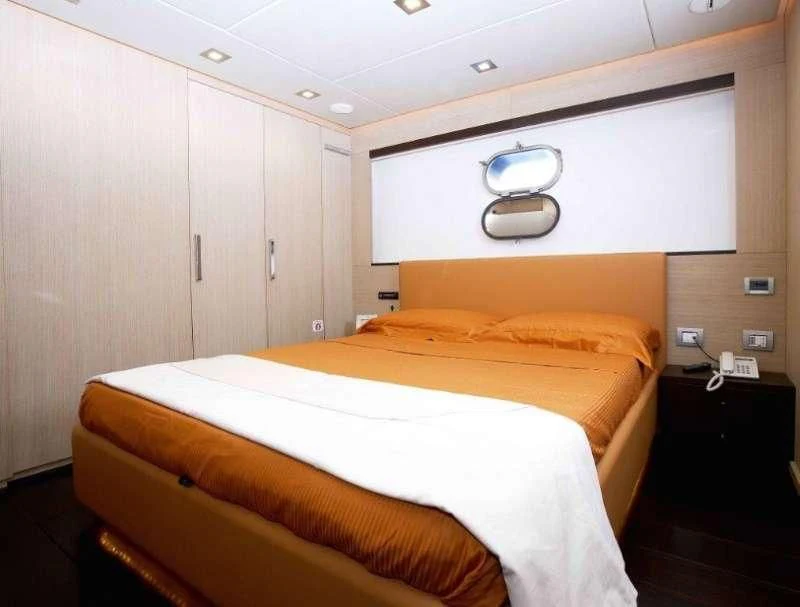 a room with a bed and a wall mounted television aboard ARIA Yacht for Sale