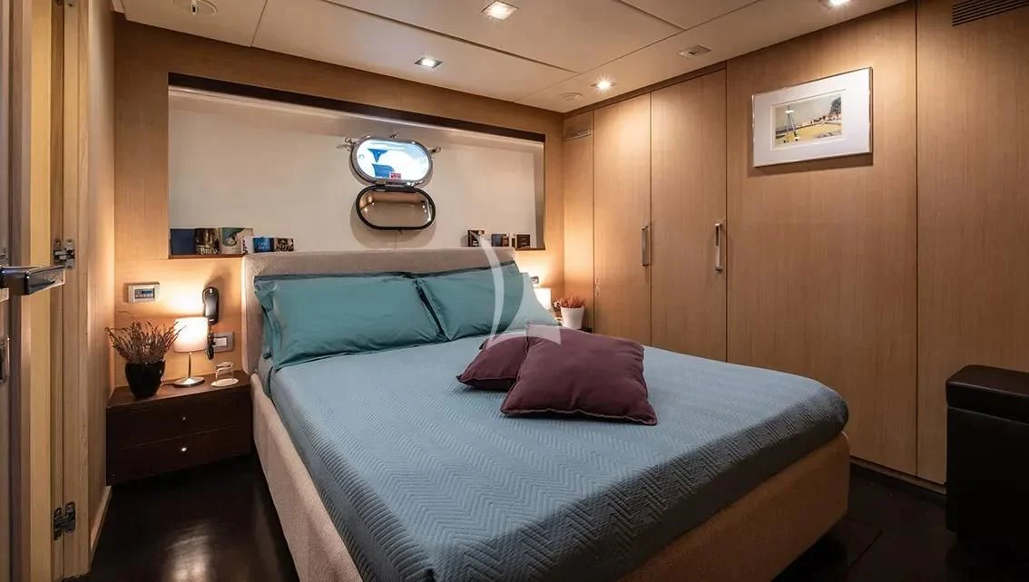a bedroom with a bed and a desk aboard ARIA Yacht for Sale