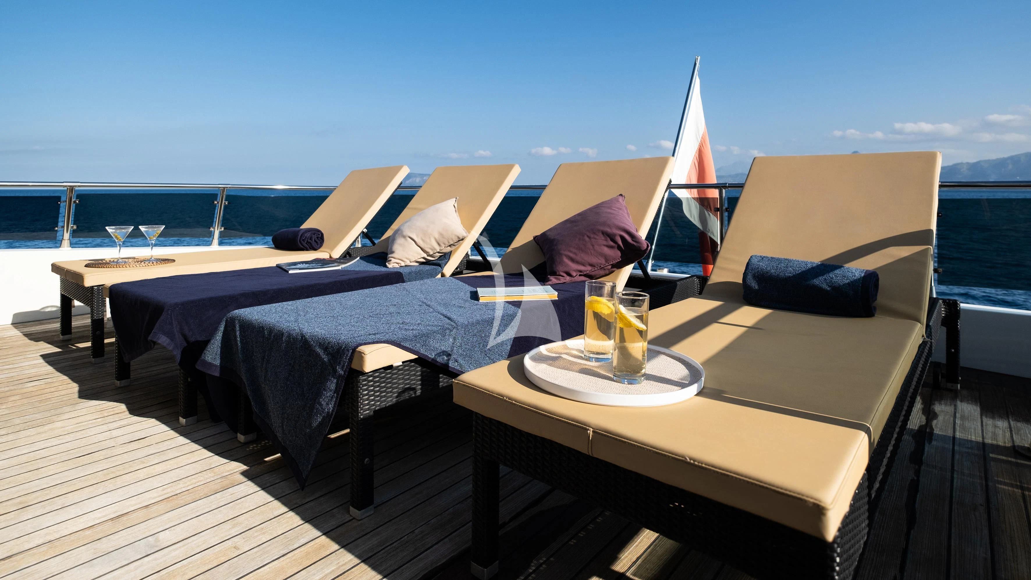 a bed with a table and chairs on a deck aboard ARIA Yacht for Sale