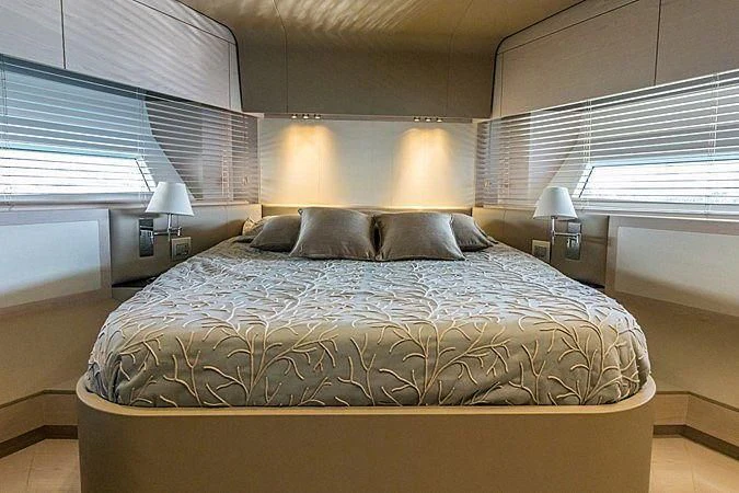 a bed with a blue comforter aboard LENA Yacht for Sale