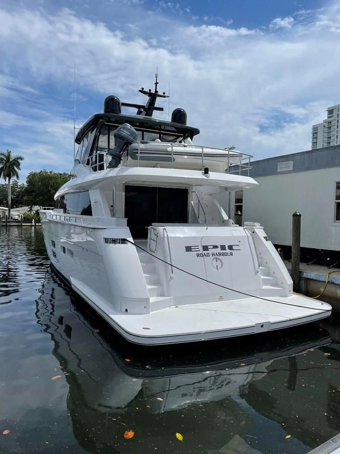 a white boat in a body of water aboard EPIC Yacht for Sale