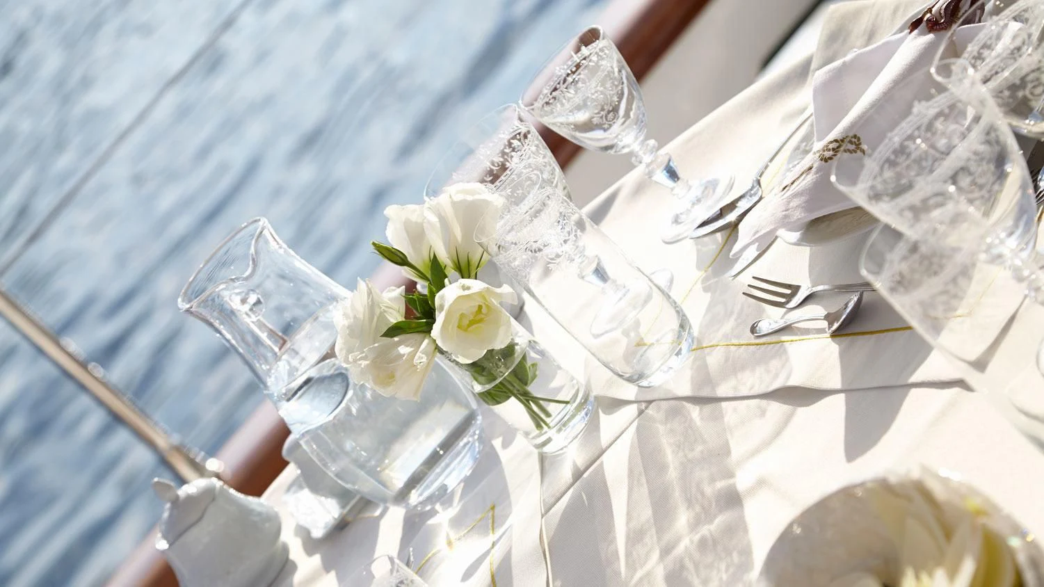 a table with a set of glasses and flowers on it aboard G GIRL Yacht for Sale