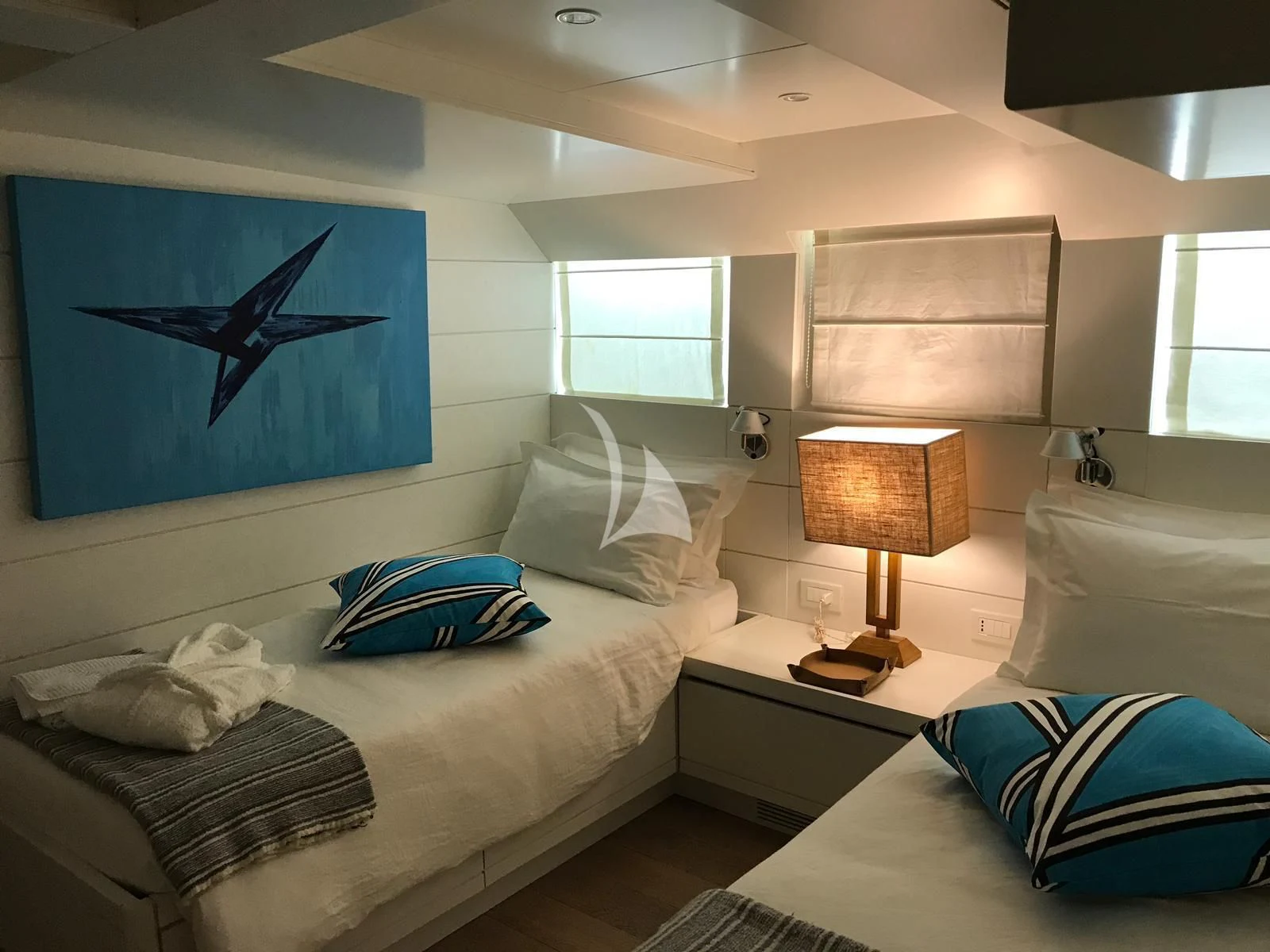 a bedroom with a bed and a lamp aboard VERVECE Yacht for Charter
