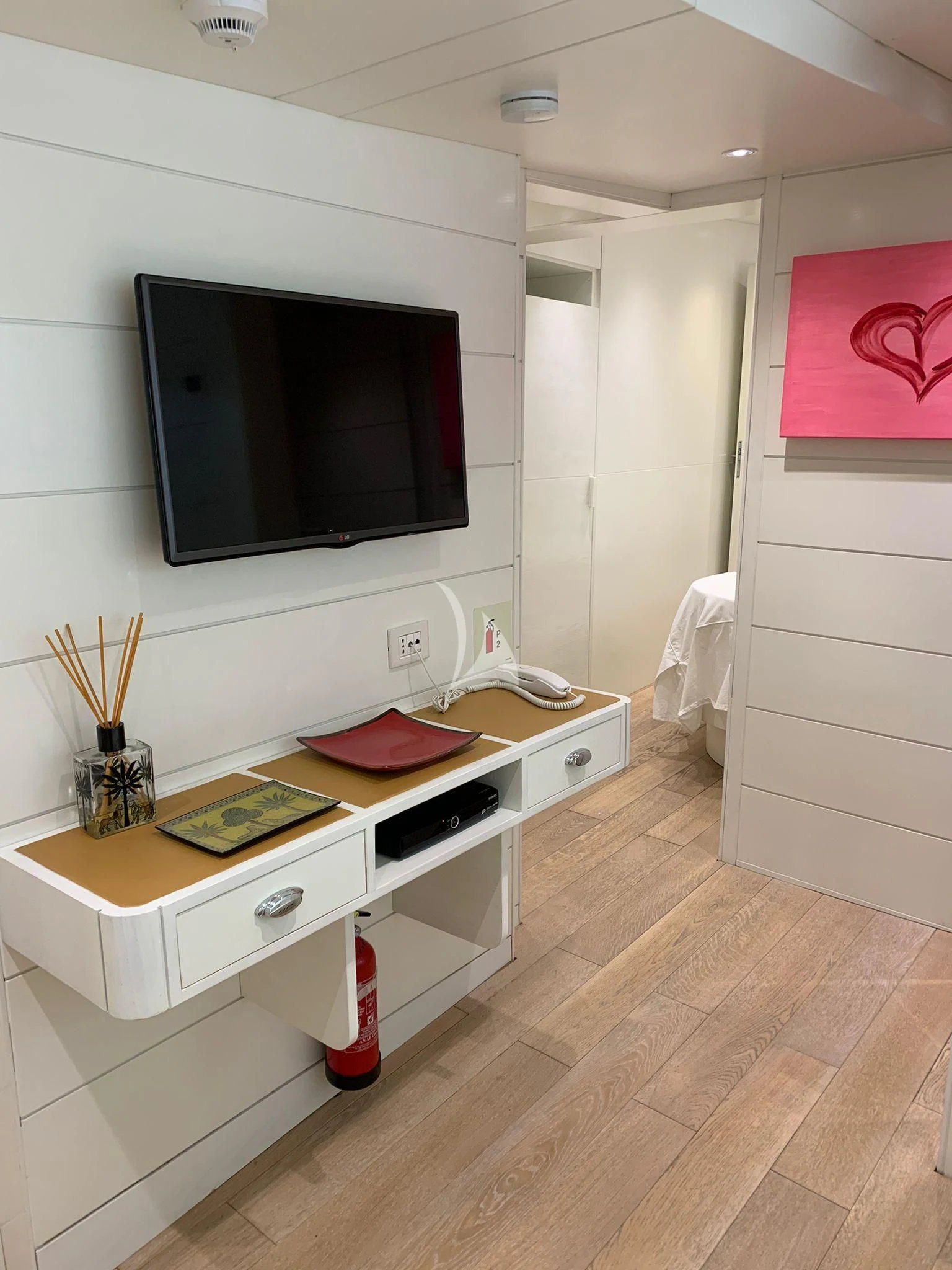 a room with a tv and a dresser aboard VERVECE Yacht for Charter