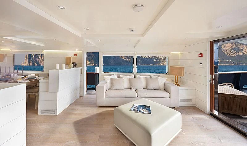 a living room with a large white sofa and a large screen aboard VERVECE Yacht for Charter