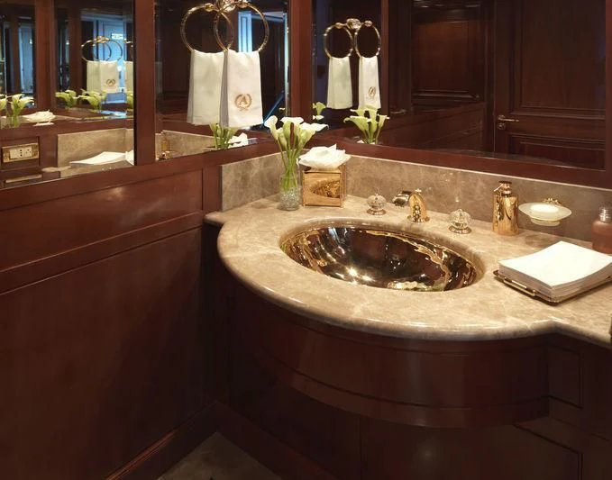 a bathroom sink with a vase of flowers on it aboard APOGEE Yacht for Sale
