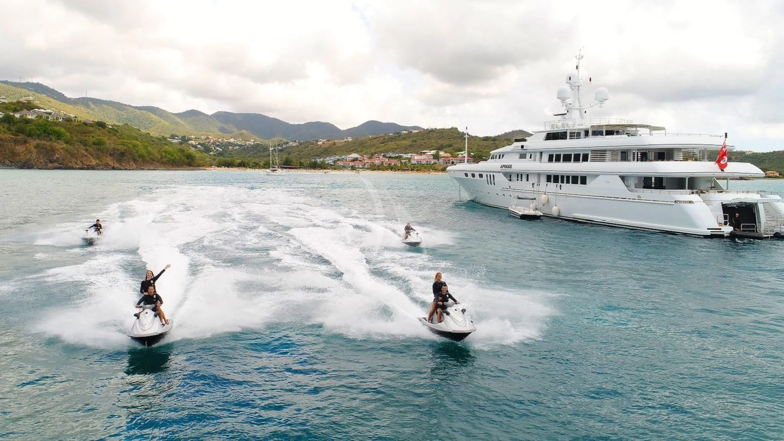 a group of people on surfboards in the water by a boat aboard APOGEE Yacht for Sale