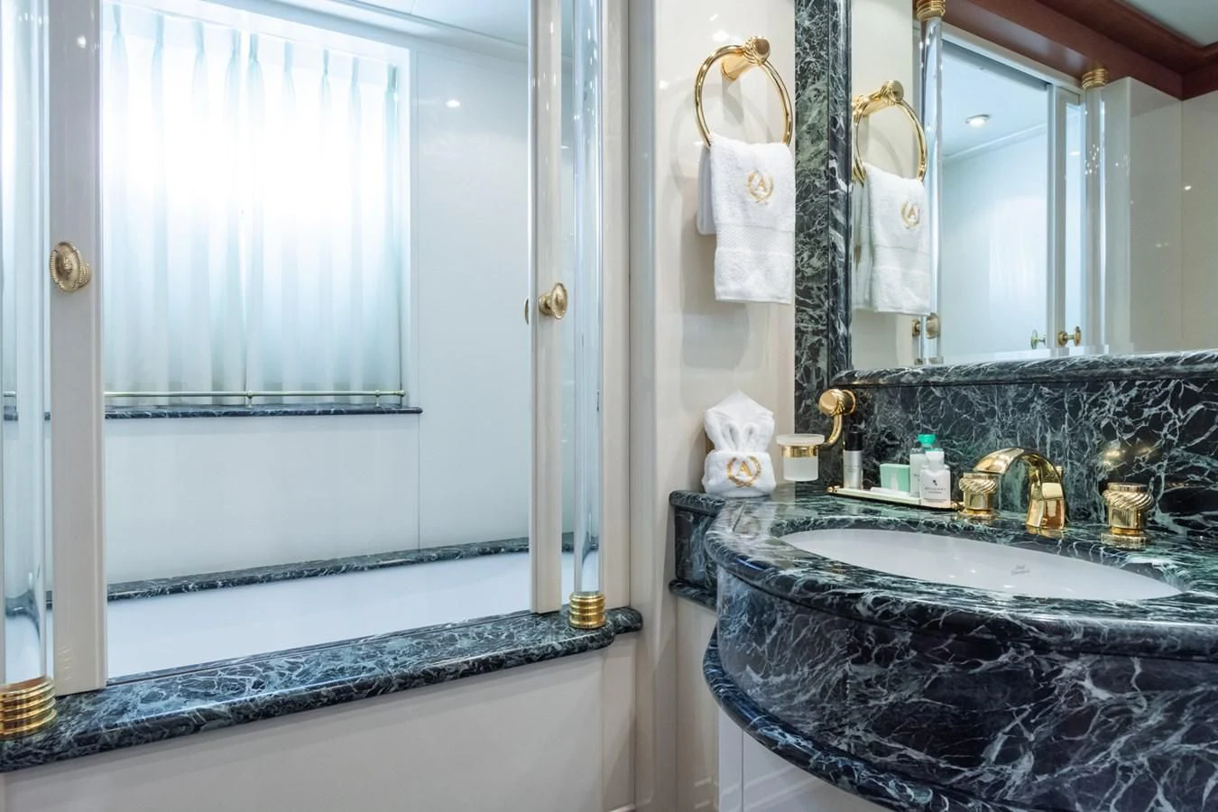 a bathroom with a tub sink and a large mirror aboard APOGEE Yacht for Sale