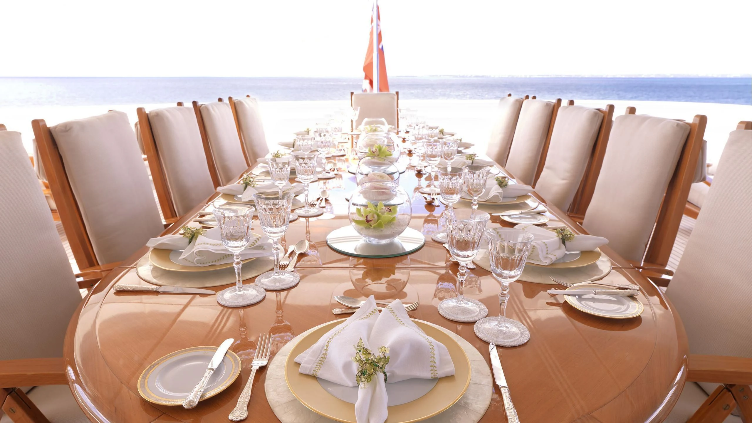 a table set with plates and glasses aboard APOGEE Yacht for Sale