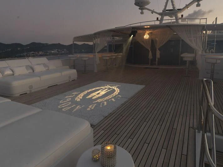 a deck with a deck and a pool with a plane in the background aboard APOGEE Yacht for Sale
