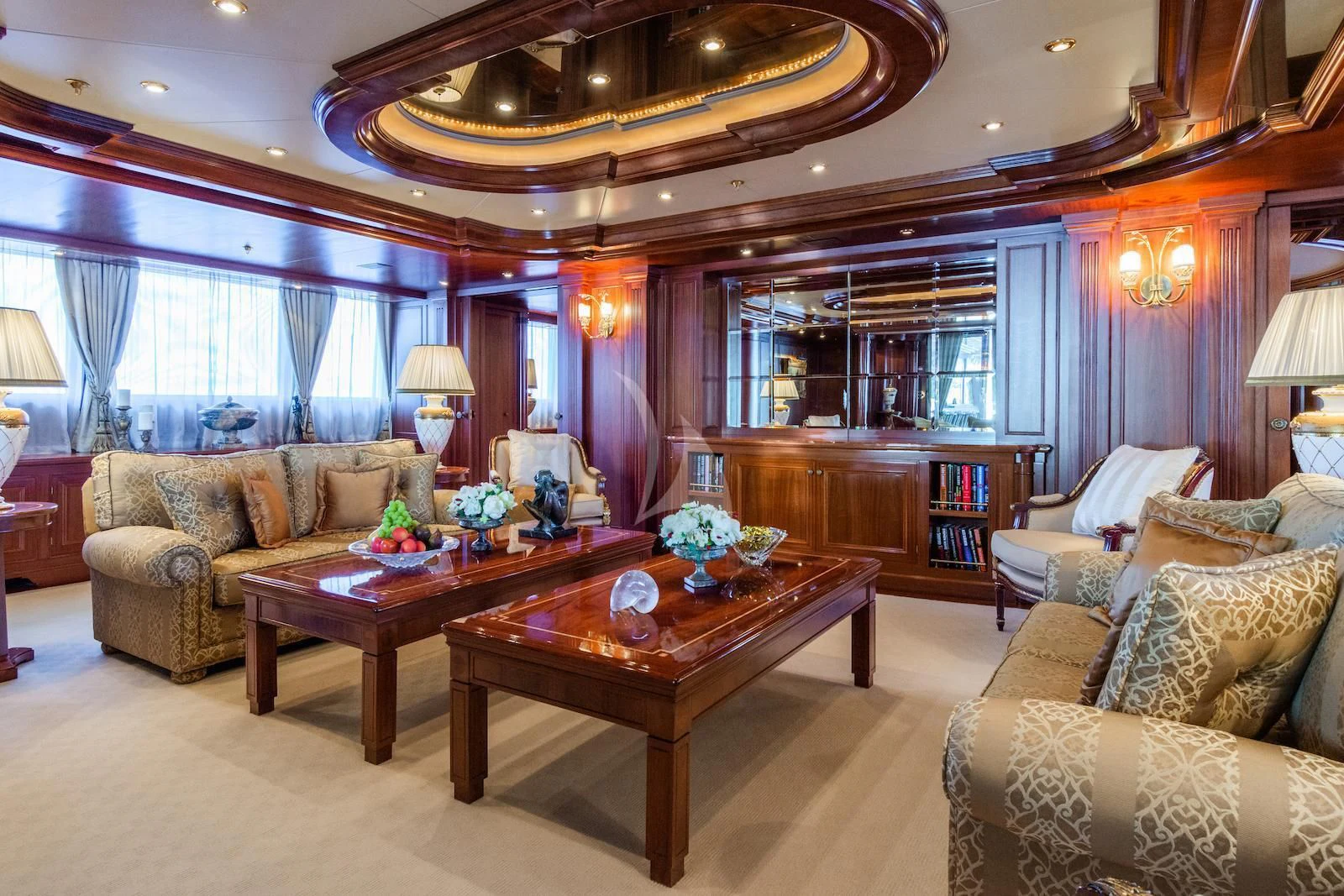 a living room with a table and couches aboard APOGEE Yacht for Sale
