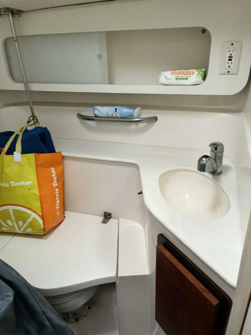 a bathroom sink with a yellow bucket aboard SERENITY Yacht for Charter