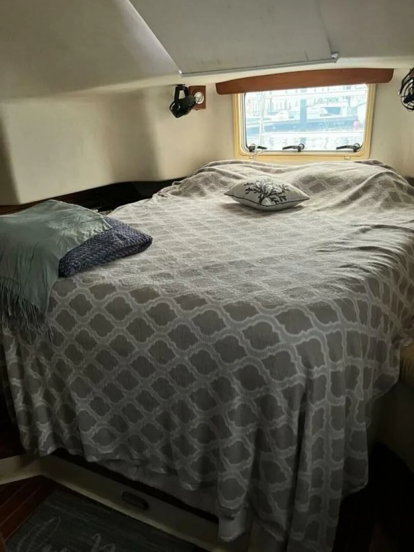 a bed with a white comforter aboard SERENITY Yacht for Charter