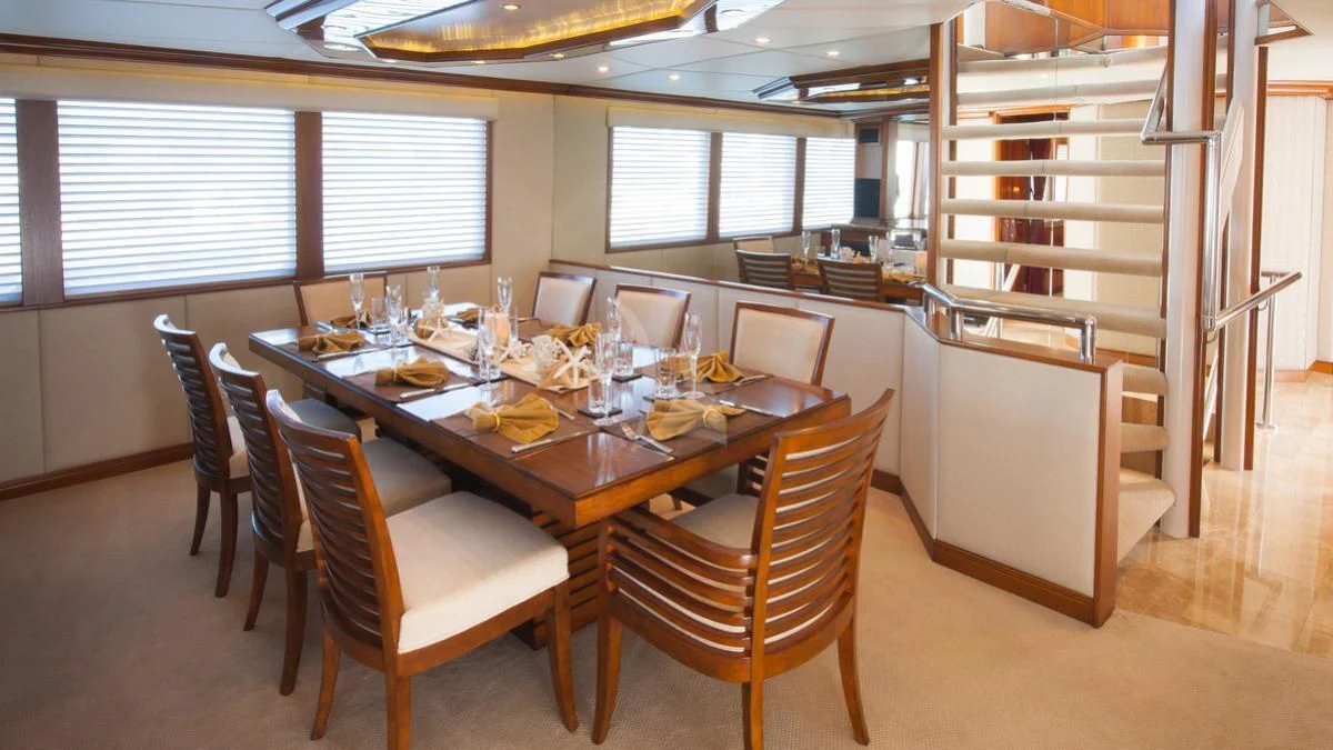 a dining table with chairs aboard SERENITY Yacht for Charter