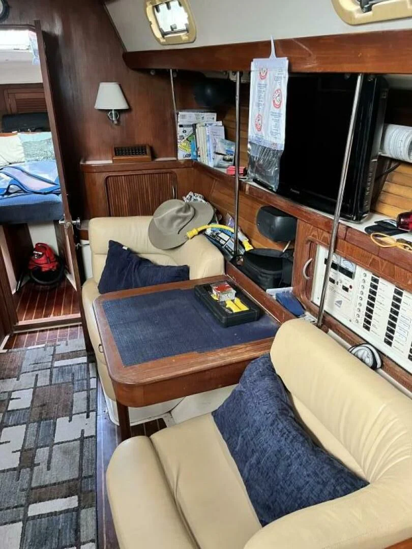 a living room with a tv and a table aboard SERENITY Yacht for Charter