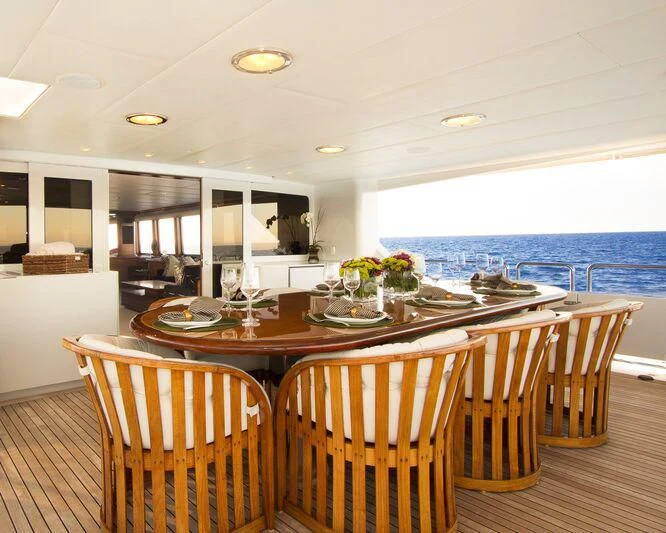 a dining table with chairs and a view of the water aboard SERENITY Yacht for Charter