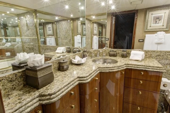 a bathroom with a countertop sink and a large mirror aboard SERENITY Yacht for Charter