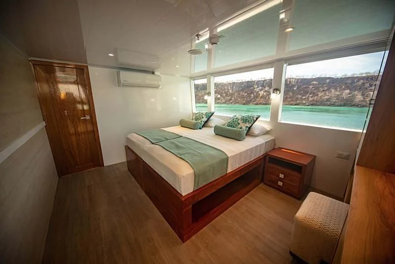 a room with a bed and a window aboard GRAND DAPHNE Yacht for Charter