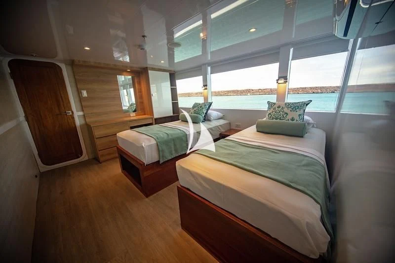a room with a bed and a table aboard GRAND DAPHNE Yacht for Charter