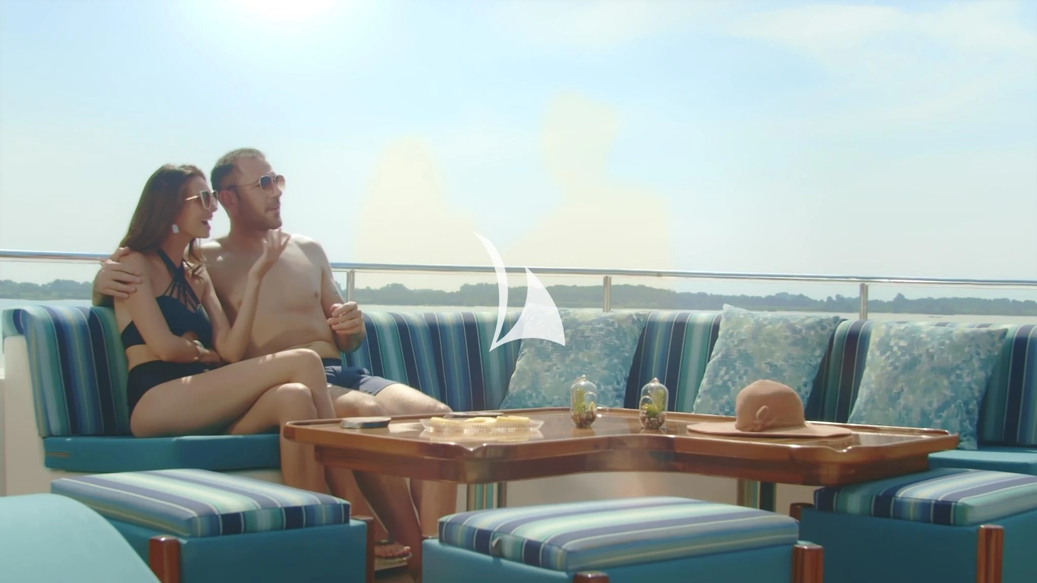 a man and woman sitting on a couch aboard GRAND DAPHNE Yacht for Charter