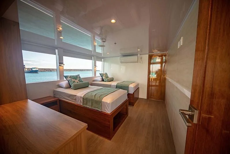 a room with a bed and a table aboard GRAND DAPHNE Yacht for Charter