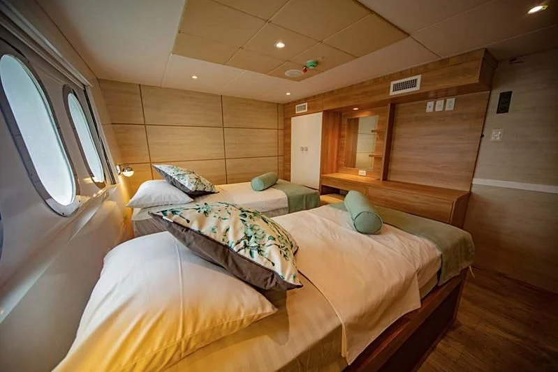 a room with beds and a window aboard GRAND DAPHNE Yacht for Charter