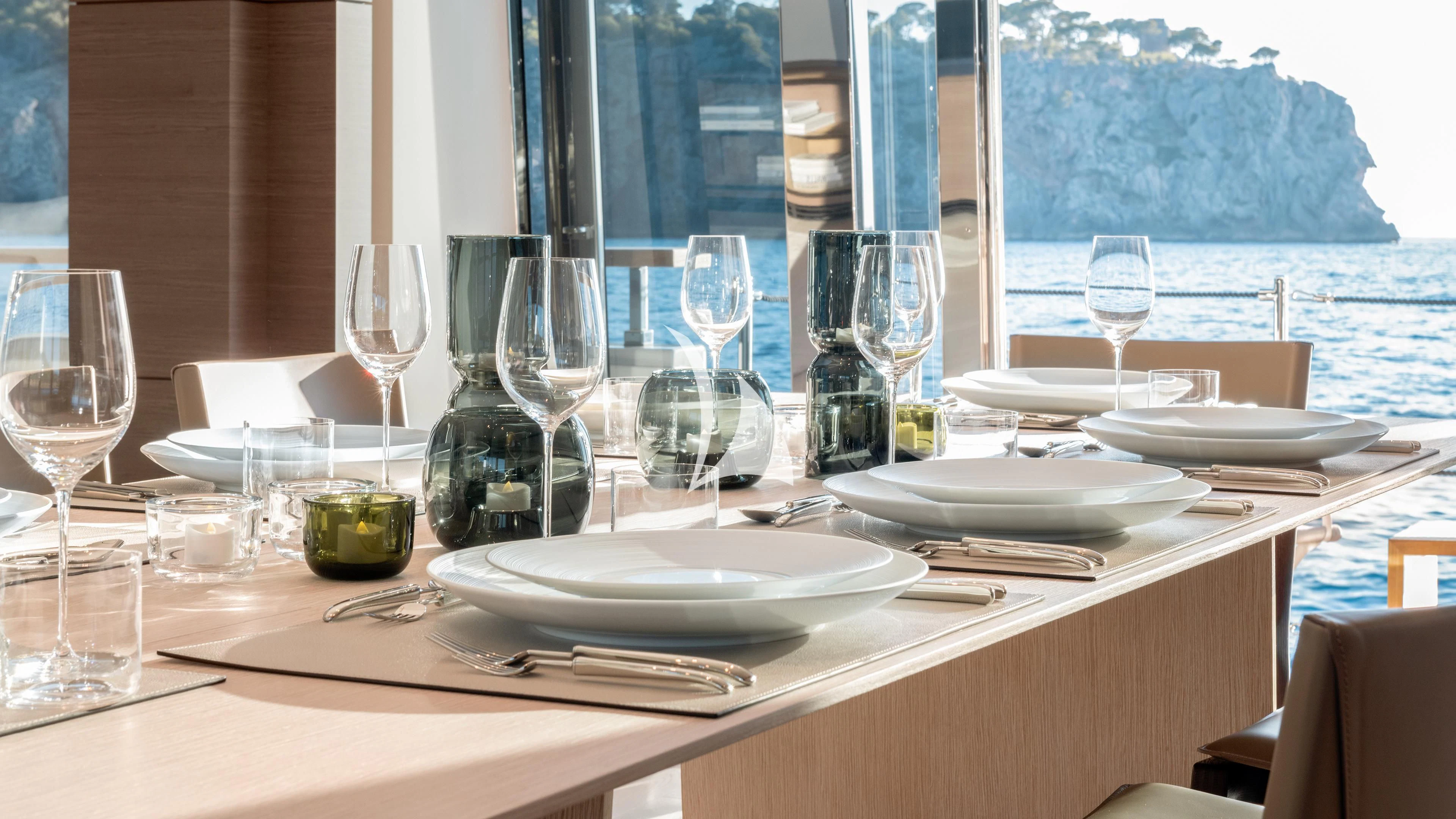 a table with wine glasses and plates aboard PALOMA Yacht for Sale