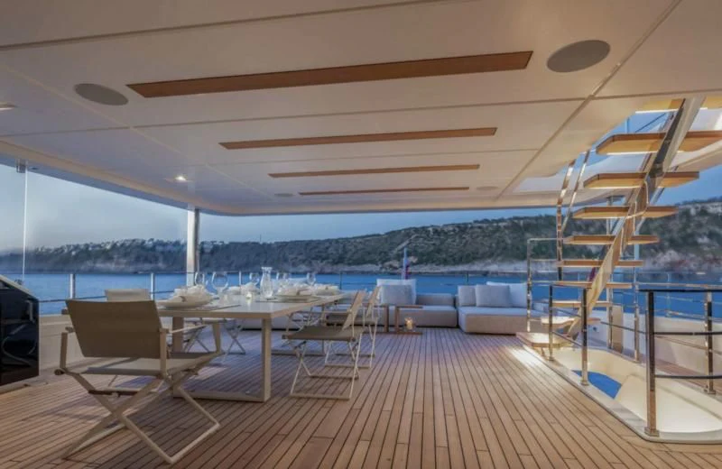 a deck with a view of the ocean and a large boat aboard PALOMA Yacht for Sale