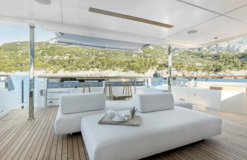 a large white lounge chair on a deck overlooking a large body of water aboard PALOMA Yacht for Sale