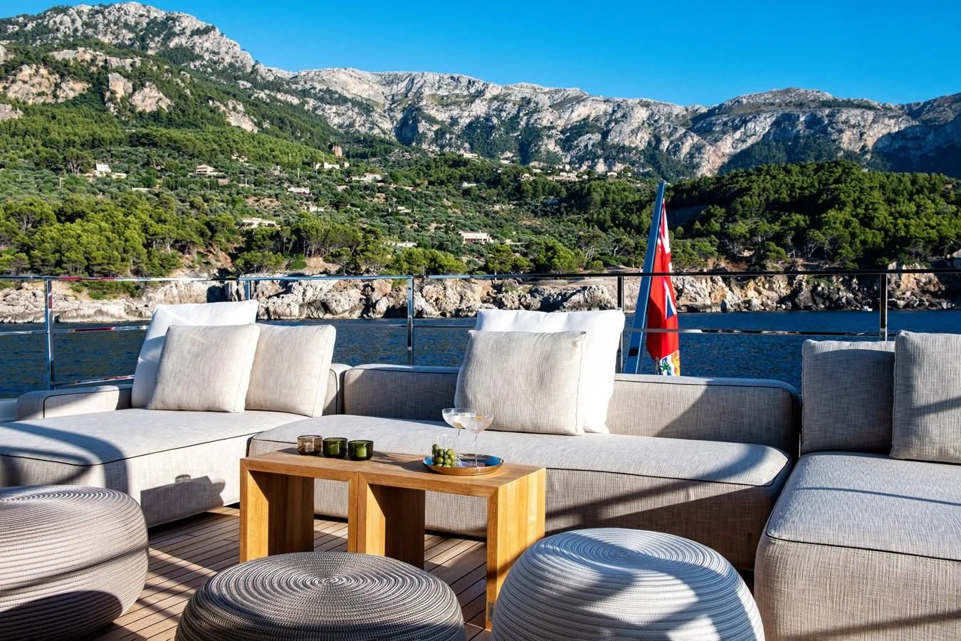 a living room with a large body of water and mountains in the background aboard PALOMA Yacht for Sale