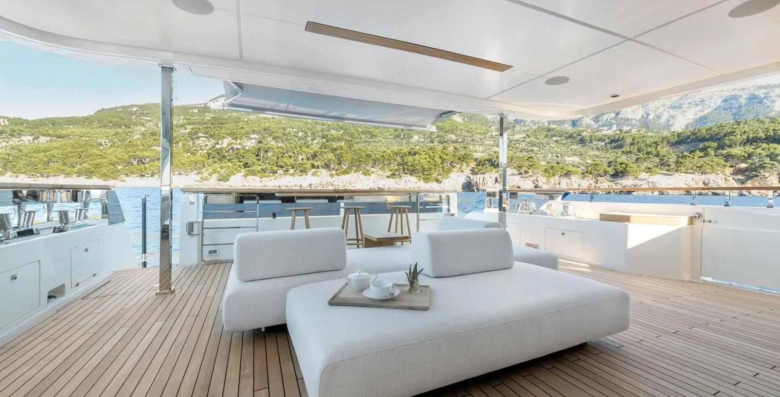 a large white bed on a deck overlooking a large body of water aboard PALOMA Yacht for Sale
