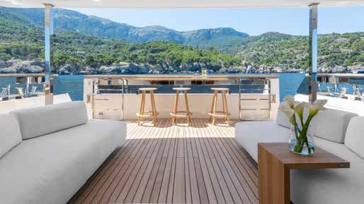 a room with a couch and a table and a view of a city aboard PALOMA Yacht for Sale
