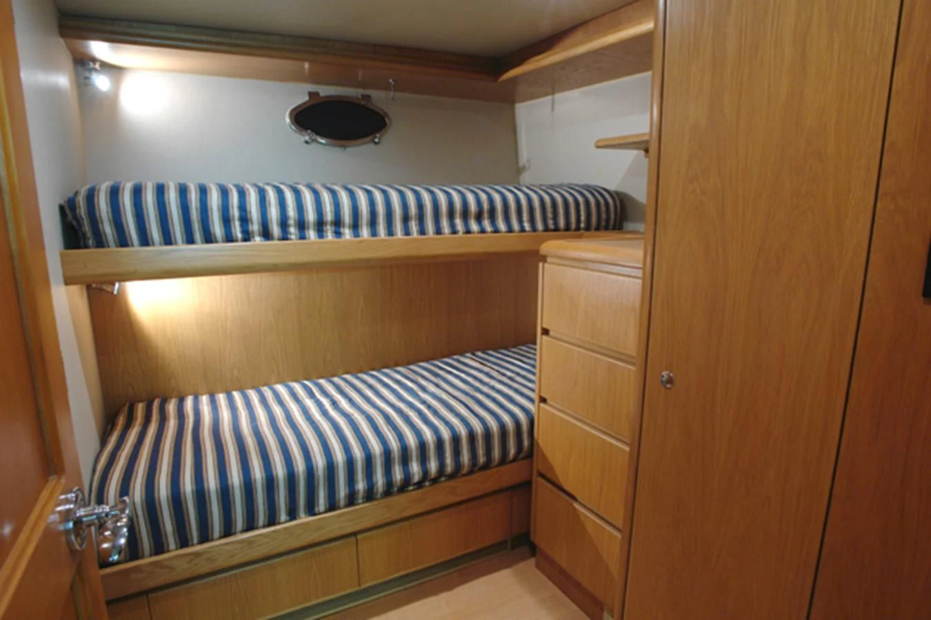 a bunk bed with a blue and white striped sheet aboard SANTO ANTONIO Yacht for Sale