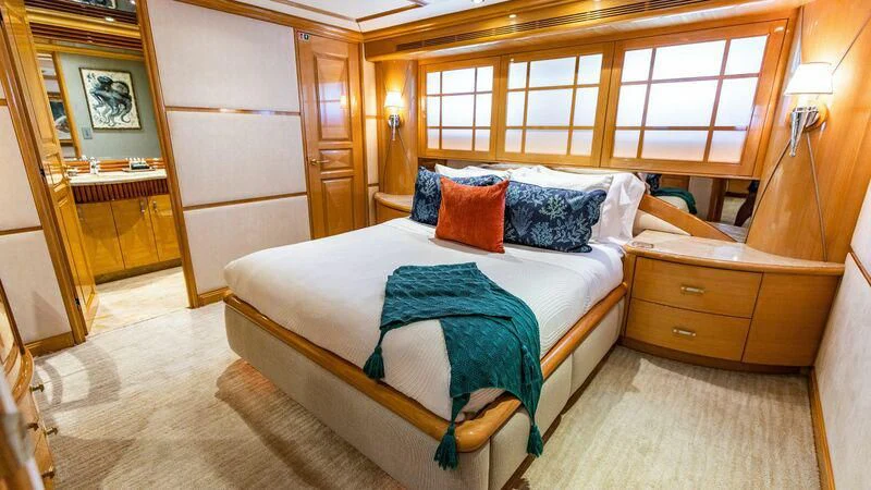 a bedroom with a bed and a dresser aboard SEAQUEST Yacht for Sale