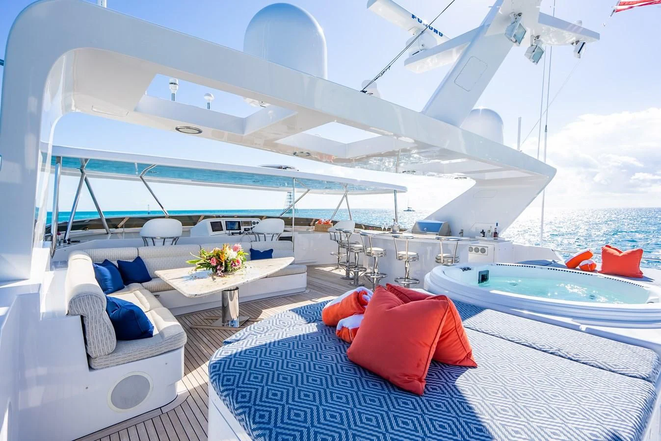 a large white boat with a red pillow on a blue and white striped bed and white pillows on aboard SEAQUEST Yacht for Sale