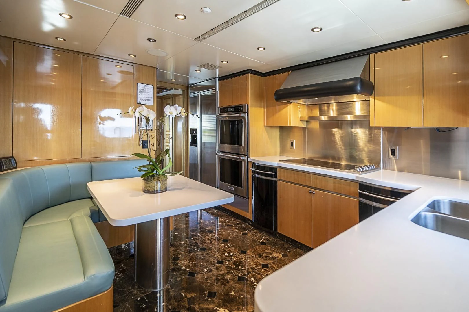 a kitchen with a table and a refrigerator aboard SEAQUEST Yacht for Sale