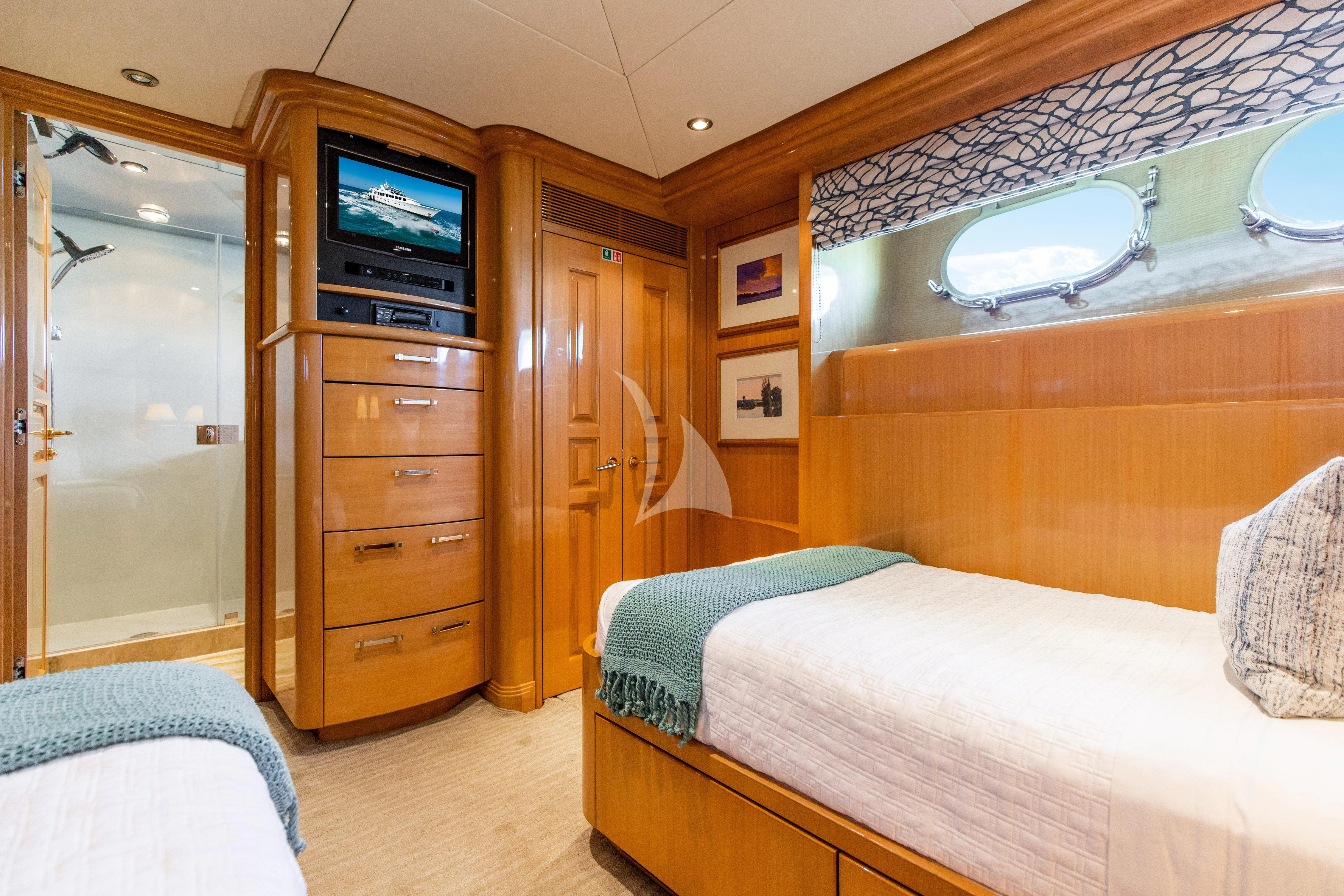 a bedroom with a bed and a television aboard SEAQUEST Yacht for Sale