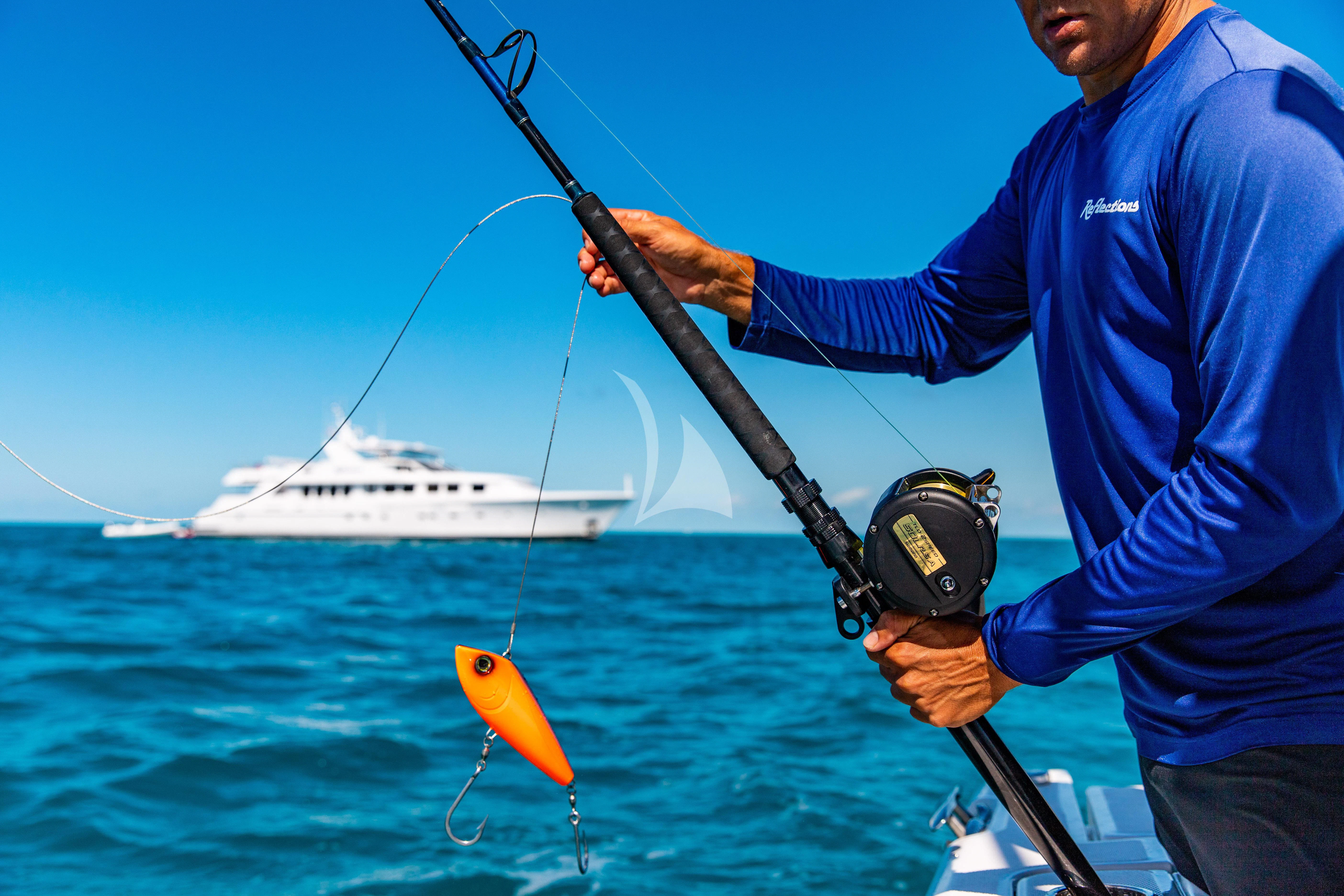 a man holding a fishing pole aboard SEAQUEST Yacht for Sale