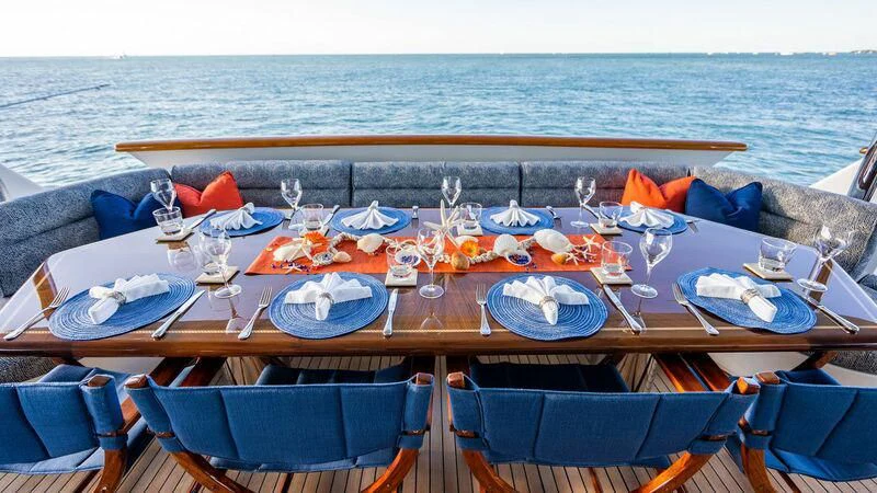 a table with chairs and umbrellas on it by the water aboard SEAQUEST Yacht for Sale
