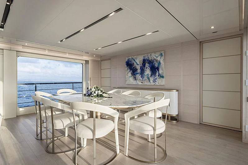 a room with tables and chairs aboard KIMOJO Yacht for Sale