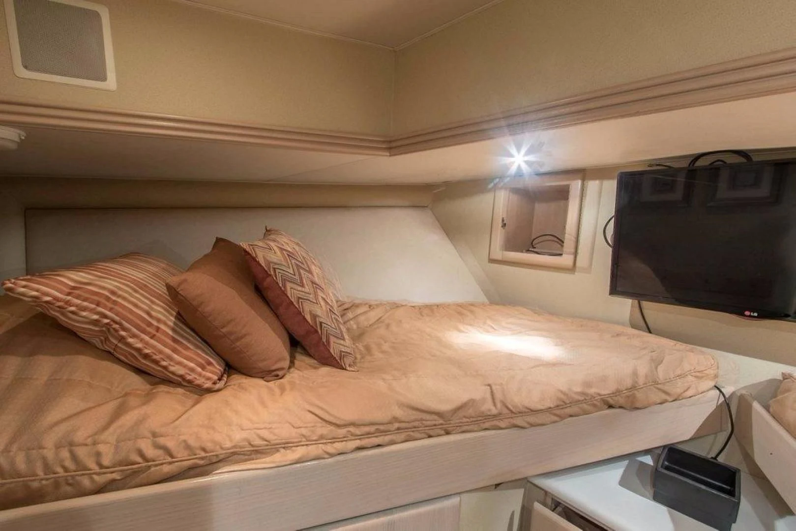 a bed with a television on the wall aboard MONARCH Yacht for Sale