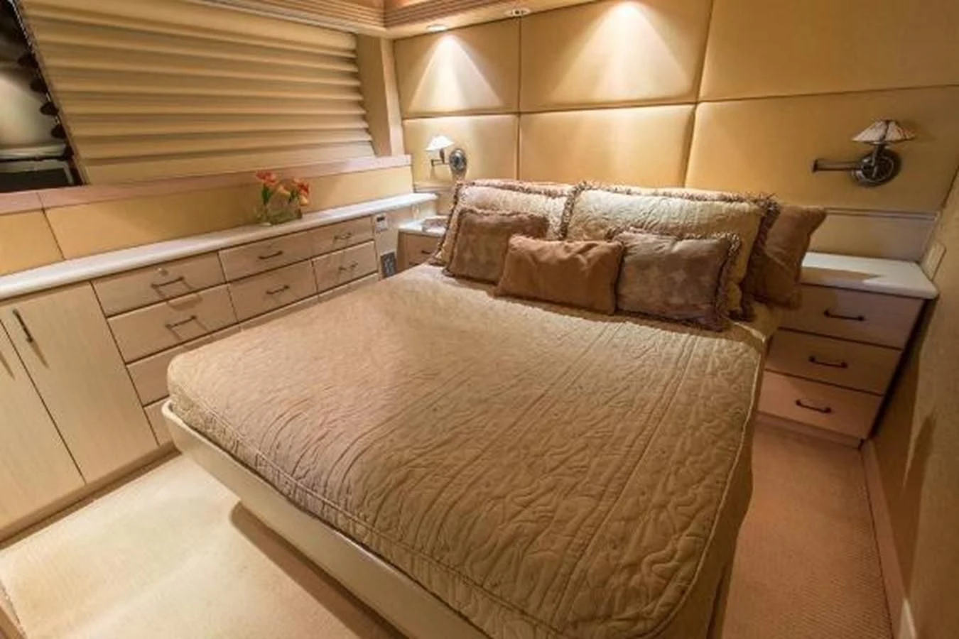 a bedroom with a bed and dresser aboard MONARCH Yacht for Sale