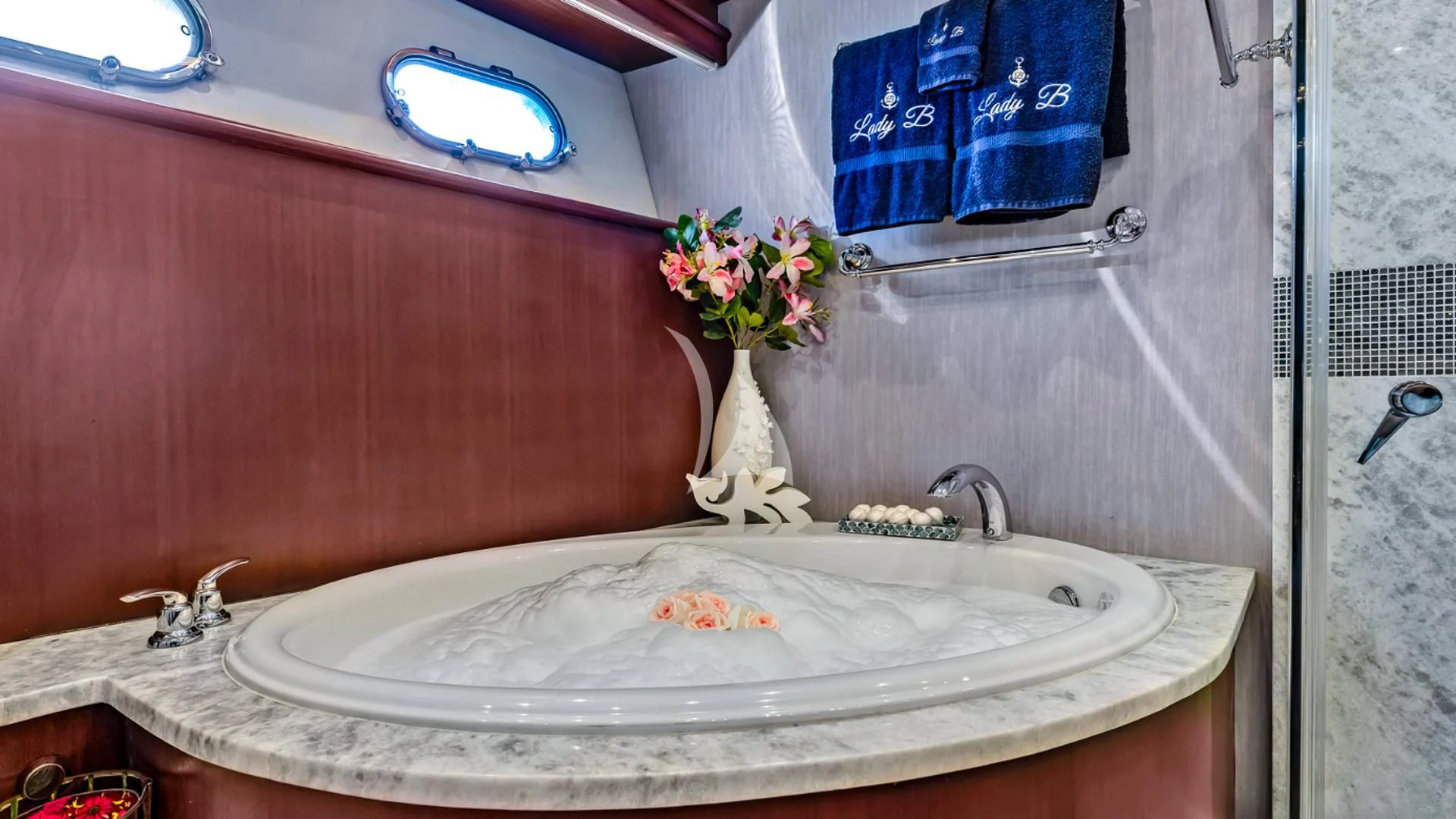 a bathroom with a sink and a vase with flowers aboard LADY B Yacht for Charter